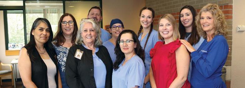 photo of Health District Family Dental Clinic staff standing in clinic lobby with welcoming smiles